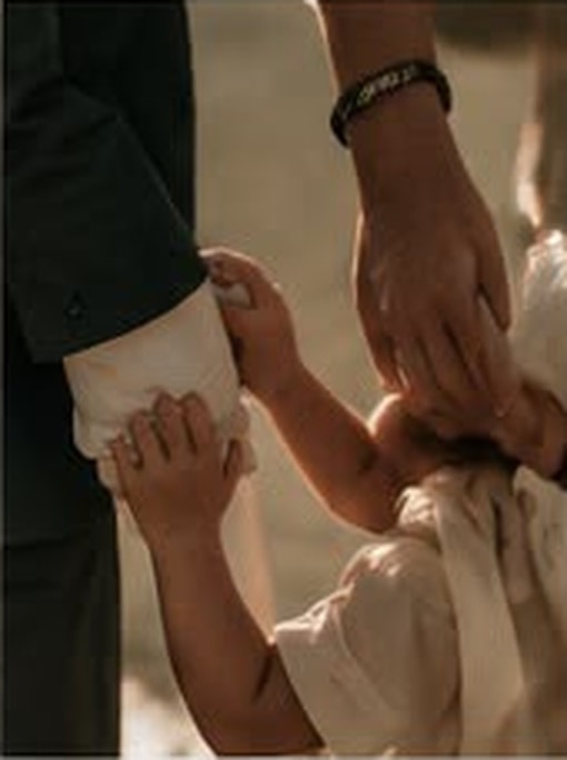 Casal de mãos dadas com o filho em momento familiar acolhedor.